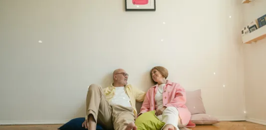 A elderly couple resting together on the floor