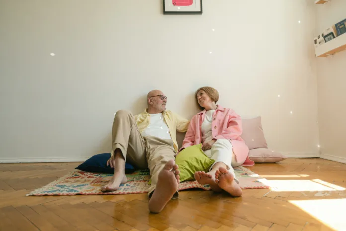 A elderly couple resting together on the floor