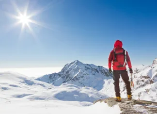 Kilian Jornet: Nevidna meja Climber looking at a snowy mountain landscape in a sunny winter day.. Western Alps, Biella, Italy.
