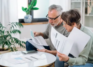 Zmanjšajte stroške za ogrevanje, električno energijo in vodo Elderly couple checking documents with tax and internal bills, making payments and discussing budget. Family calculating funds for purchase new home or car.