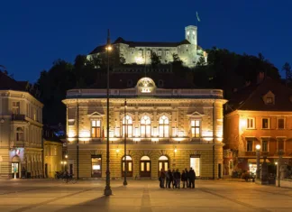 Janez Dovč: Sozvočja Slovenije Trio Ljubljana, Slovenia - October 4, 2018: The Slovenian Philharmonic Building on the background of Ljubljana Castle in dusk. The building was constructed in 1891 by design of the Austrian architect Adolf Wagner. The castle was founded in the 11th century.
