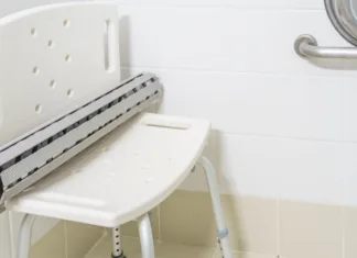 Kako poskrbeti za varno kopalnico? Non slip rubber bath mat on the plastic chair in hospital bathroom and shower