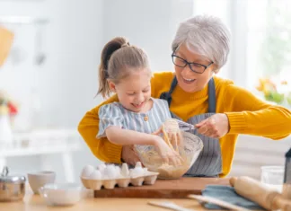 Ideje za jedi, ki jih brez slabe vesti pripravite vnukom Happy loving family are preparing bakery together. Granny and child are cooking cookies and having fun in the kitchen.