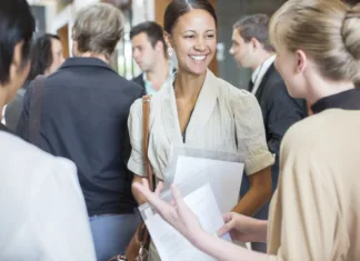 Izzivi s katerimi se srečujejo zdravstveni start-upi Portrait of two smiling women holding files and talking, standing in crowded lobby