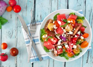 Naj recepti za osvežilne poletne jedi Watermelon and mixed tomato salad with feta cheese, overhead scene on rustic blue wood