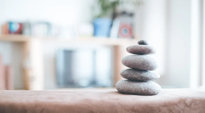 Feng Shui: Stone cairn in the foreground, blurry living room in the background. Balance and relaxation.