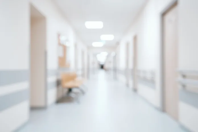 Bright, empty defocused hospital corridor background with copy space