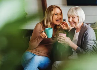S kavo proti Alzheimerjevi in Parkinsonovi, ima pa tudi negativne učinke Happy senior mother with adult daughter sitting on couch and holding cups with coffee or tea at home. Togetherness concept