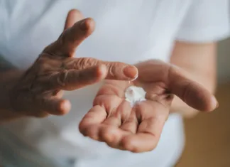 Suha in pordela koža jeseni? Tako si lahko pomagate Older woman applying cream on hands. Closeup portrait. Therapy treatment, beauty skin care. Anti-aging skincare. Anti-aging skin lifting beauty.