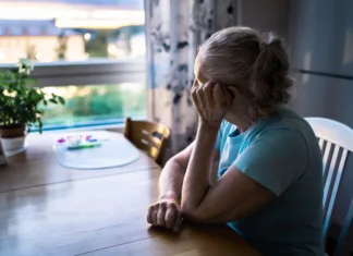 Soočanje z izgubo in žalovanjem Sad old woman. Depressed lonely senior lady with alzheimer, dementia, memory loss or loneliness. Elder person looking out the home window. Sick patient with disorder. Pensive grandma. Widow with grief