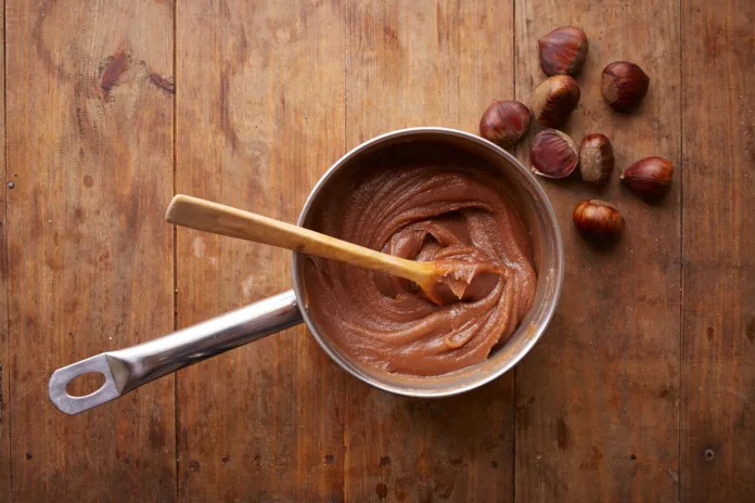 Preparing homemade chestnut cream on a pot on wooden table overlook shot