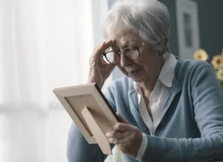 Kako olajšati bolečino na prvi dan mrtvih brez ljubljene osebe Sad woman at home grieving the loss of her husband, she is holding a picture and crying
