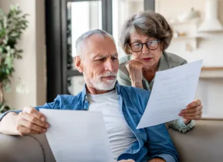 ZPIZ svetuje: Bolj ugodno se je upokojiti konec letošnjega leta kot v začetku prihodnjega Senior old elderly spouses grandparents reading documents, having issue problem debt with money loss, doing paperwork together at home. Mortgage, loan and commerce procedures