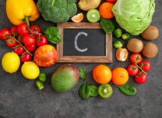 Kaj je skorbut: simptomi, vzroki in preventiva Assortment of high vitamin A sources on dark background: spinach, tomatoes, potatoes, broccoli, cabbage, Brussels sprouts, kiwi fruits, mango, granadilla, lemons, peppers, ,mandarines. Top view.