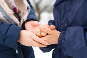 Close up picture of a woman holding her grandmother's aged hands