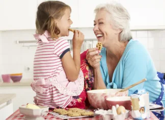 Pripravite krhke maslene piškote, en dva tri! Otroci bodo navdušeni Grandmother And Granddaughter Baking In Kitchen Smiling And Laughing At Each Other.