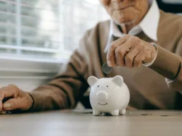 Saving money investment for future. old man hand putting money coins in a piggy bank.investment, money, annuity insurance, saving for retirement and pension fund concept.Individual retirement account.