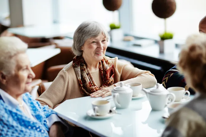 Senior woman sitting in cafe with friends