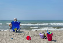 Preprosta poletna navada, ki krepi možgane Relaxing in a beach chair on the sandy beach overlooking the Atlantic Ocean in Atlantic Beach, North Carolina.