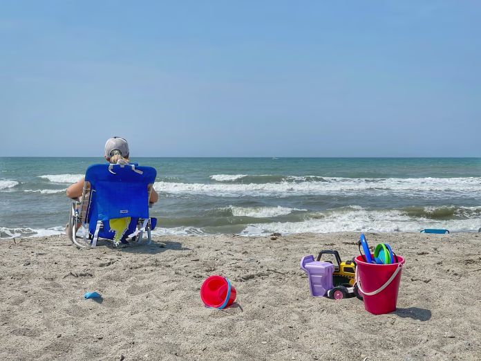 Relaxing in a beach chair on the sandy beach overlooking the Atlantic Ocean in Atlantic Beach, North Carolina.
