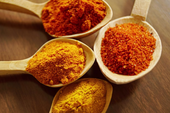 Four assorted spices on wooden spoons