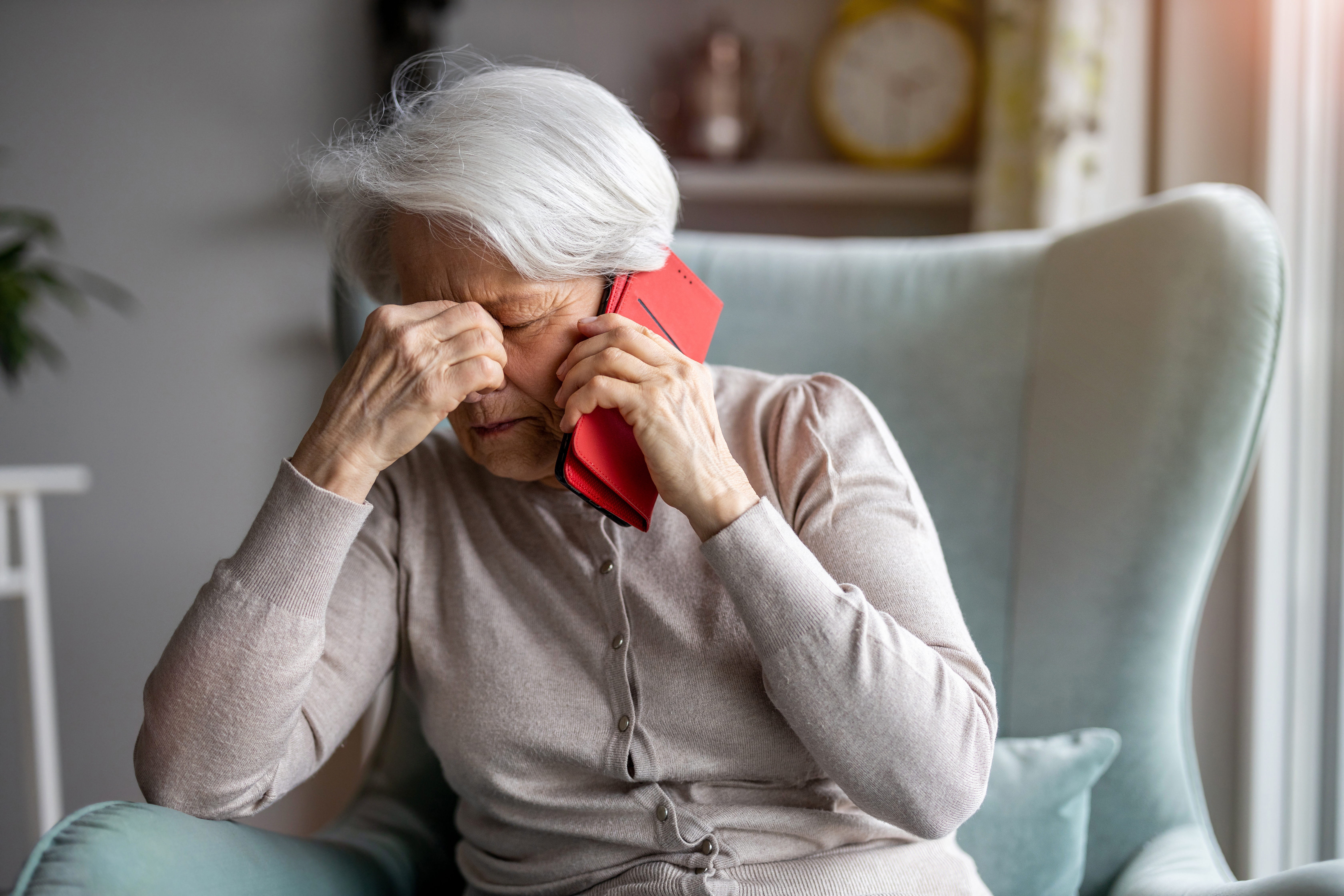 senior-woman-feeling-pain-while-consulting-doctor-on-her-smart-phone-stockpack-istock older senior phone telephone worried sad call