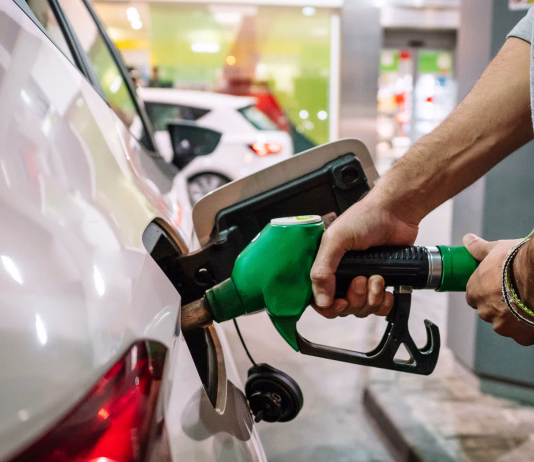 Od danes spet višje cene goriv Unrecognizable male putting fuel dispenser in tank while refueling vehicle on self service gas station. High quality photo