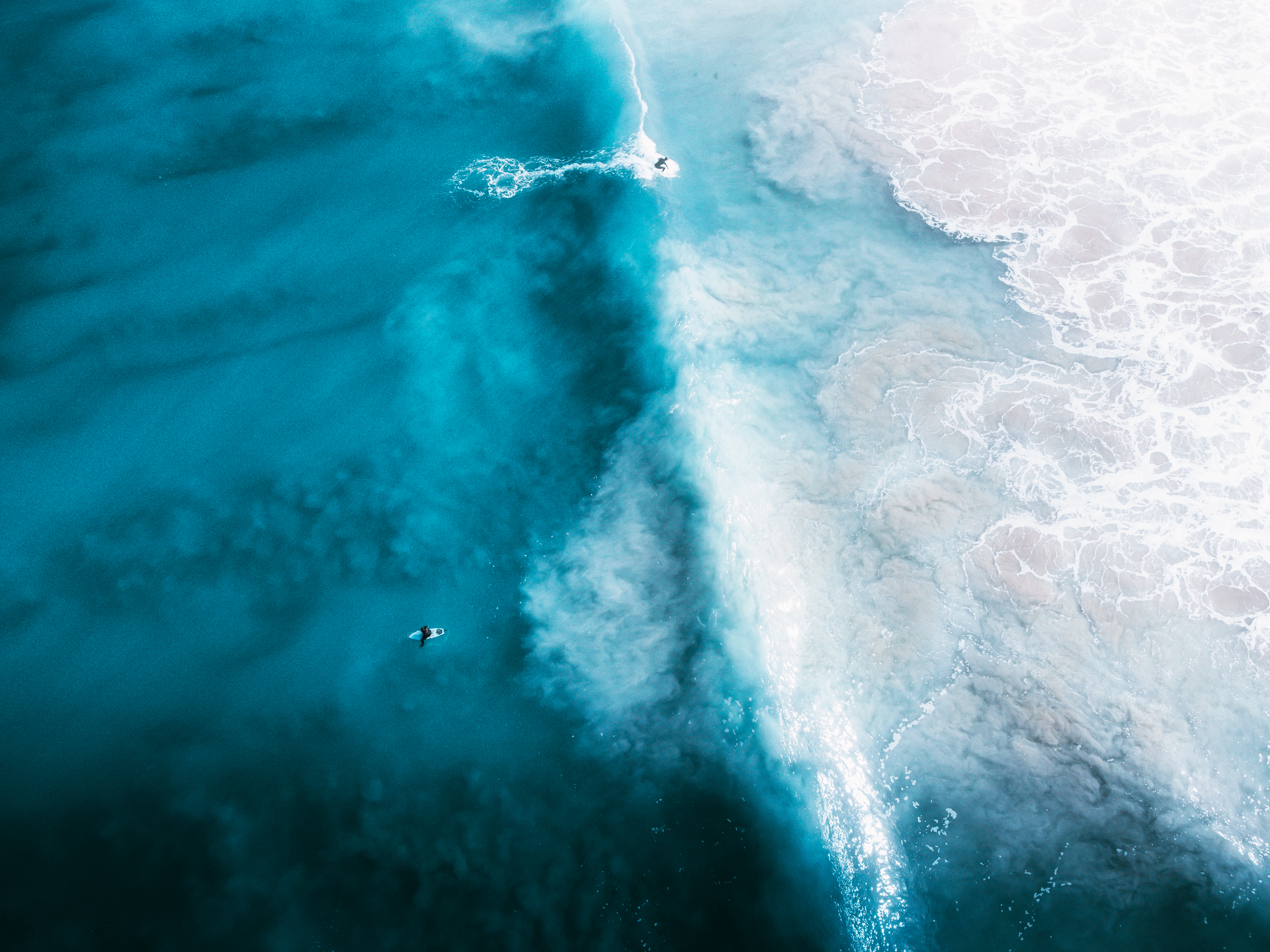 15 največjih skrivnosti oceanov Drone aerial view of surfers catching waves in ocean