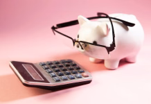 Zakaj višina pokojnine ni enaka višini prihodkov pred upokojitvijo? Piggy bank with eyeglasses and calculator on pink background