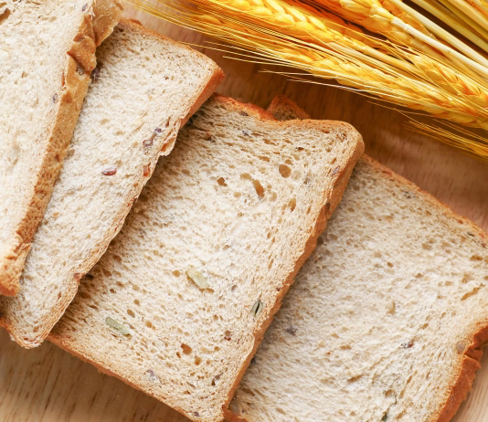 Celiakija: Bolezen, ki prizadene tanko črevo in je posledica preobčutljivosti na gluten Sliced bread on brown wooden surface