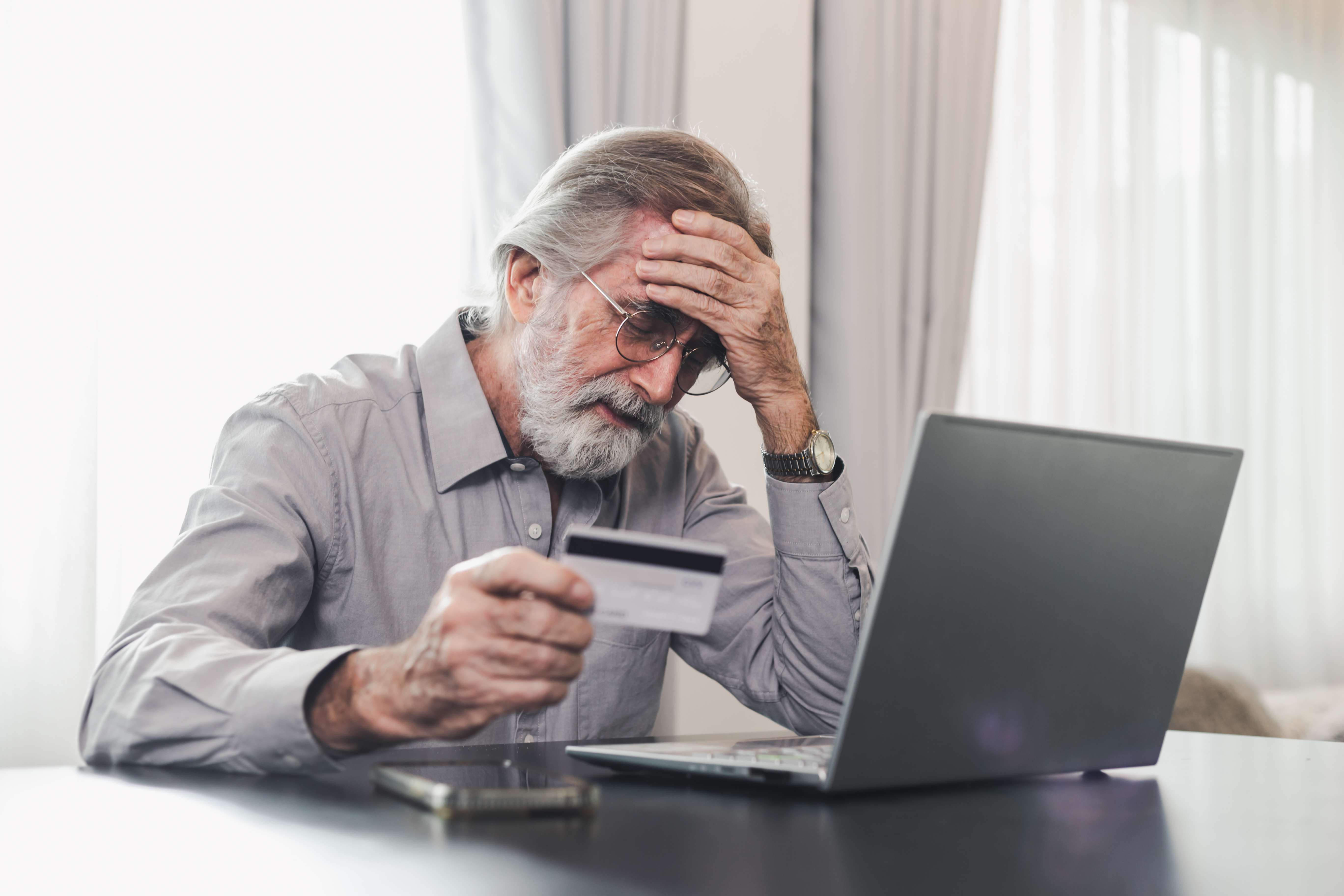 upset-senior-elderly-man-holding-credit-card-by-laptop-having-trouble-worry-finance-safety-data-or-online-payment-security-bank-client-concerned-about-problem-with-credit-card-financial-fraud-threat-stockpack-istock Upset senior elderly man holding credit card by laptop having trouble worry finance safety data or online payment security. Bank client concerned about problem with credit card, financial fraud threat