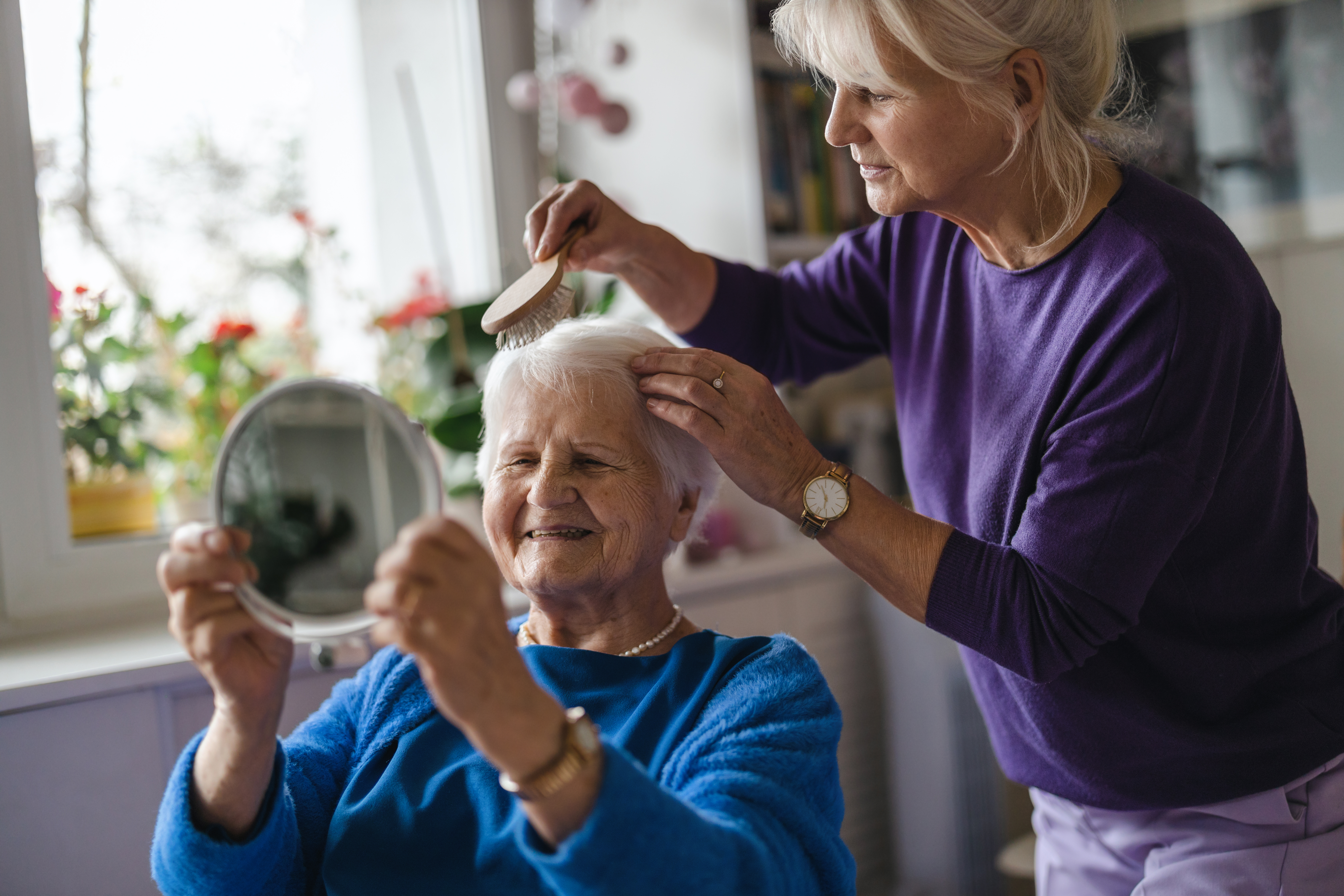 woman-combing-hair-of-elderly-mother-stockpack-istock Woman combing hair of elderly mother