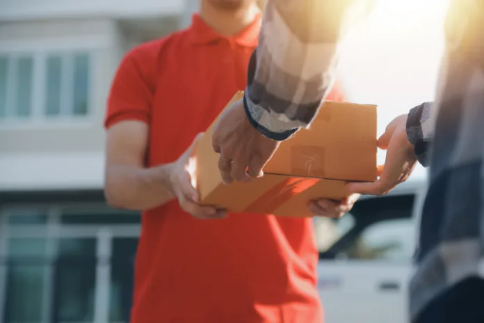 asian-delivery-express-courier-young-man-use-giving-boxes-to-woman-customer-he-wearing-protective-face-mask-at-front-home-stockpack-istock Asian delivery express courier young man use giving boxes to woman customer he wearing protective face mask at front home