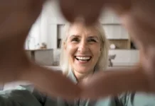 Huda vročina: pogostejši klici in obiski starejših lahko preprečijo resne težave Close up face happy older woman look at camera forming heart shape with her hands, expressing love and connection through video call, highlighting warmth and affection, share tenderness and gratitude