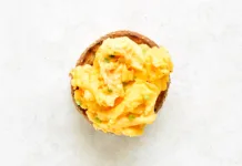 Večina ljudi vse življenje pripravlja umešana jajca narobe. Ta preprost trik naredi veliko razliko Diet scrambled eggs on toasted brioche bun on light background. Tasty meal for breakfast or brunch. Top view, flat lay