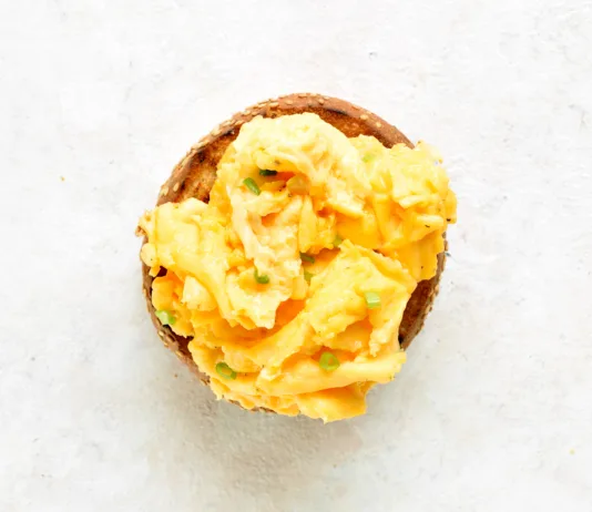 Večina ljudi vse življenje pripravlja umešana jajca narobe. Ta preprost trik naredi veliko razliko Diet scrambled eggs on toasted brioche bun on light background. Tasty meal for breakfast or brunch. Top view, flat lay