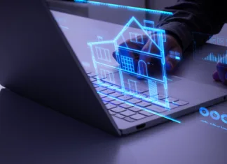 Zaostruje se vpogled v Zemljiško knjigo. Kmalu boste lahko lastništvo preverjali le z digitalno identiteto Man interacting with holographic blueprint of a house in blue color. Concept of smart home, automation, control cctv network, internet of things (iot), smart city, saving energy and air conditioning.