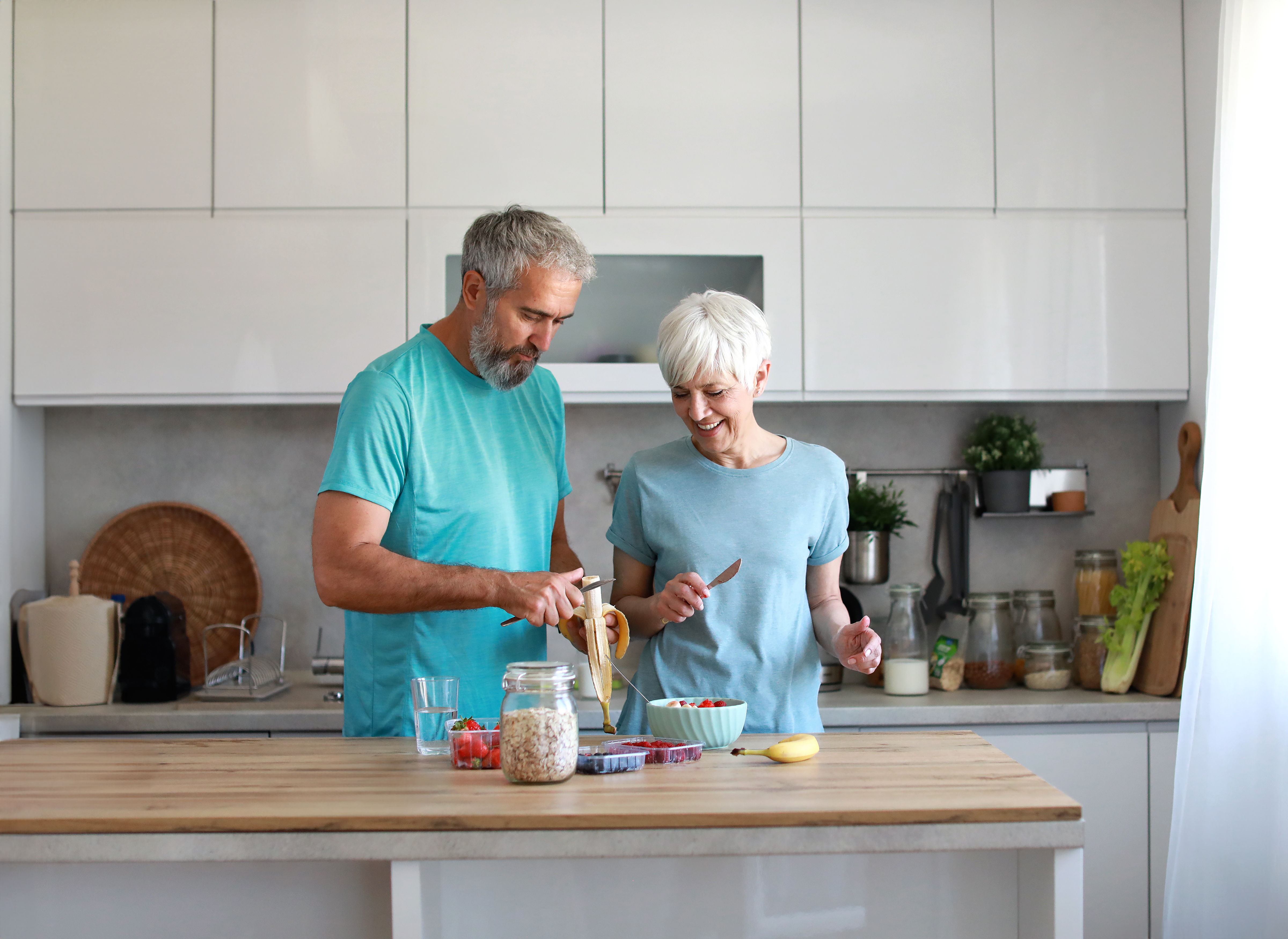 Beljakovine v zrelih letih: koliko jih potrebujemo za mišice, moč in ravnotežje ter kako jih razporediti čez dan Portrait of a senior mature couple having a healthy breakfast after fitness exercise training in the morning at home