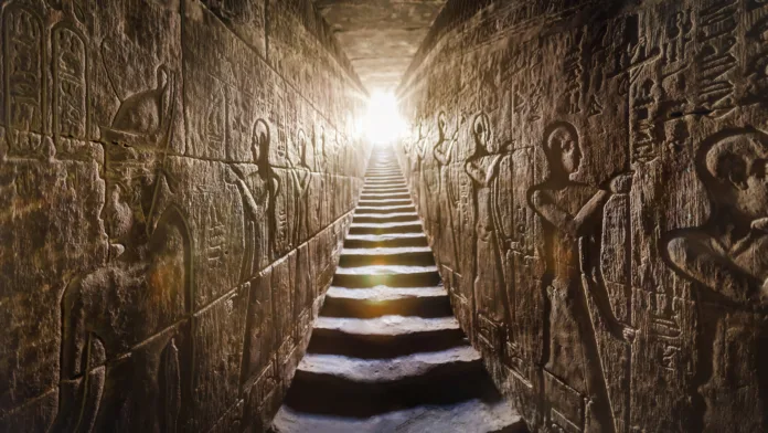 temple-of-edfu-egypt-passage-flanked-by-two-glowing-walls-full-of-egyptian-hieroglyphs-illuminated-by-a-warm-orange-backlight-from-a-door-at-the-end-of-the-stairs-stockpack-istock Temple of Edfu, Egypt. Passage flanked by two glowing walls full of Egyptian hieroglyphs, illuminated by a warm orange backlight from a door at the end of the stairs.