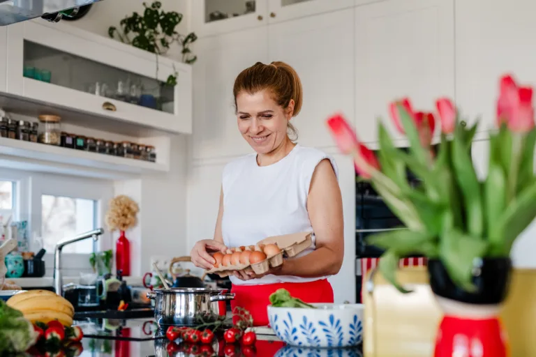 Woman preparing healthy breakfast with eggs in modern kitchen.