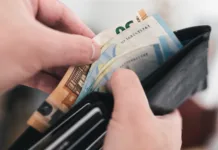 Na račune prihaja vračilo dohodnine: preverite, na kateri bančni račun bo FURS nakazal denar close-up view of hands taking money out of a wallet, spending cash concept