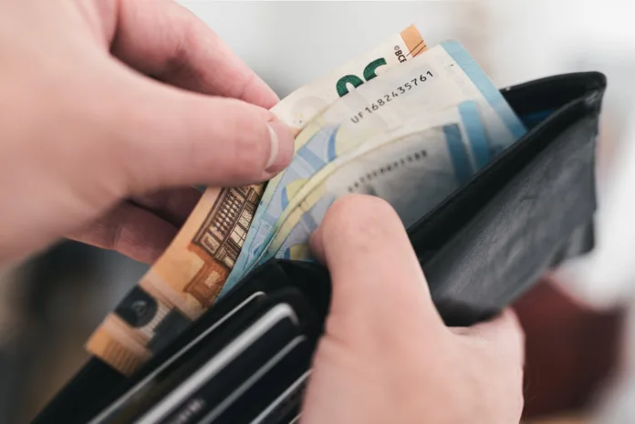 close-up-view-of-hands-taking-money-out-of-a-wallet-spending-cash-concept-stockpack-istock close-up view of hands taking money out of a wallet, spending cash concept
