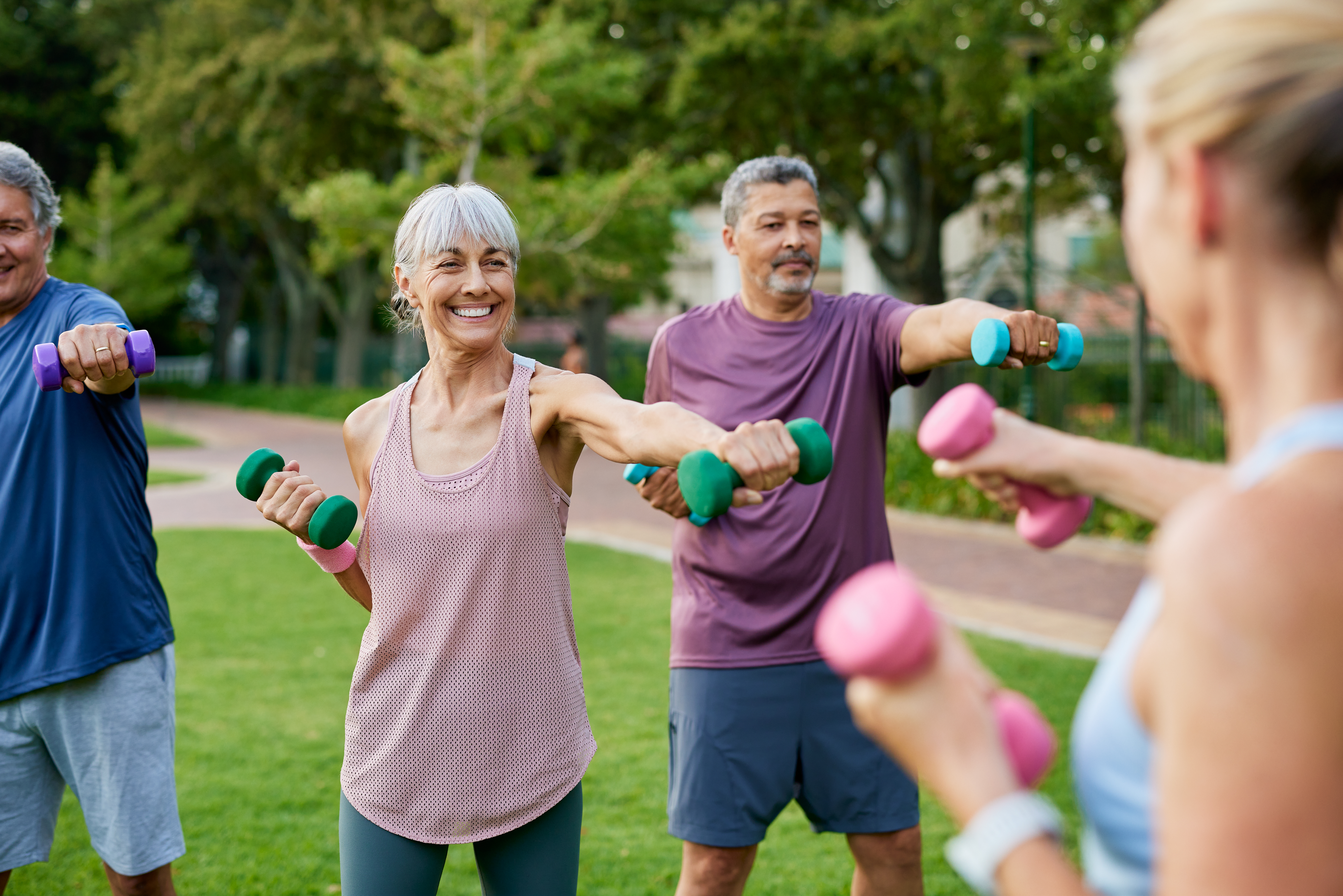 elderly-group-of-people-working-out-with-dumbbells-in-a-park-mature-fitness-group-of-women-and-men-lifting-small-weights-outdoors-happy-active-adults-in-sportswear-exercising-together-with-dumbbells-stockpack-istock Elderly group of people working out with dumbbells in a park. Mature fitness group of women and men lifting small weights outdoors. Happy active adults in sportswear exercising together with dumbbells.