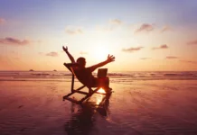 FURS odhaja na 3-tednske počitnice. Kaj to pomeni za vas? happy freelancer with laptop computer working on the beach, freelance work concept, dream office job workplace
