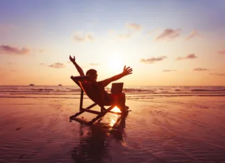 FURS odhaja na 3-tednske počitnice. Kaj to pomeni za vas? happy freelancer with laptop computer working on the beach, freelance work concept, dream office job workplace