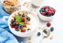 Poletni zajtrk brez občutka teže: 3 ideje za vsakogar Yogurt with fresh berries and granola on white table. Healthy snack or breakfast. Diet food.