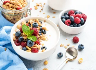 Poletni zajtrk brez občutka teže: 3 ideje za vsakogar Yogurt with fresh berries and granola on white table. Healthy snack or breakfast. Diet food.