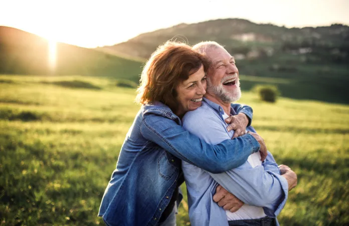 happy-senior-couple-outside-in-spring-nature-hugging-at-sunset-side-view-stockpack-istock Happy senior couple outside in spring nature, hugging at sunset. Side view.