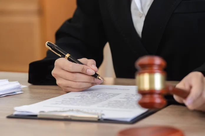 a-female-lawyer-meticulously-examines-contract-documents-related-to-a-lawsuit-highlighting-the-professional-legal-process-stockpack-istock A female lawyer meticulously examines contract documents related to a lawsuit, highlighting the professional legal process.