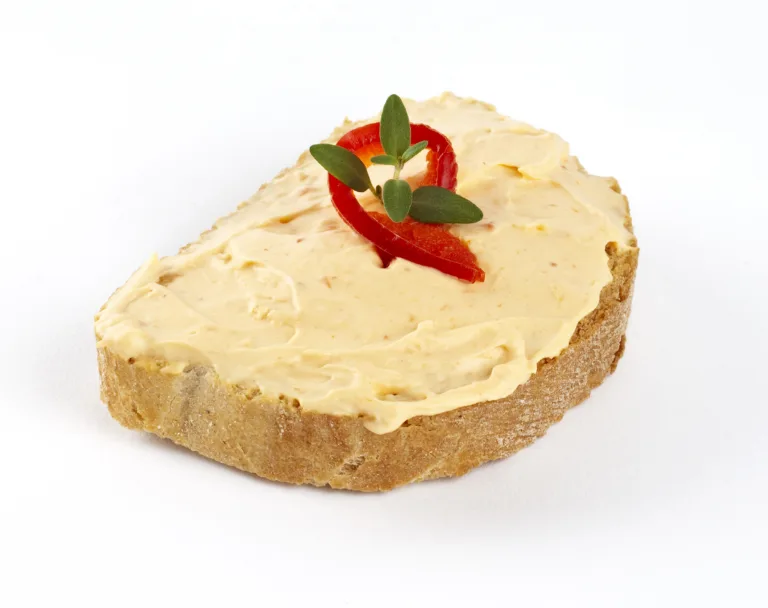 fetta spread cheese mixed with red pepper and oregano on a slice of bread